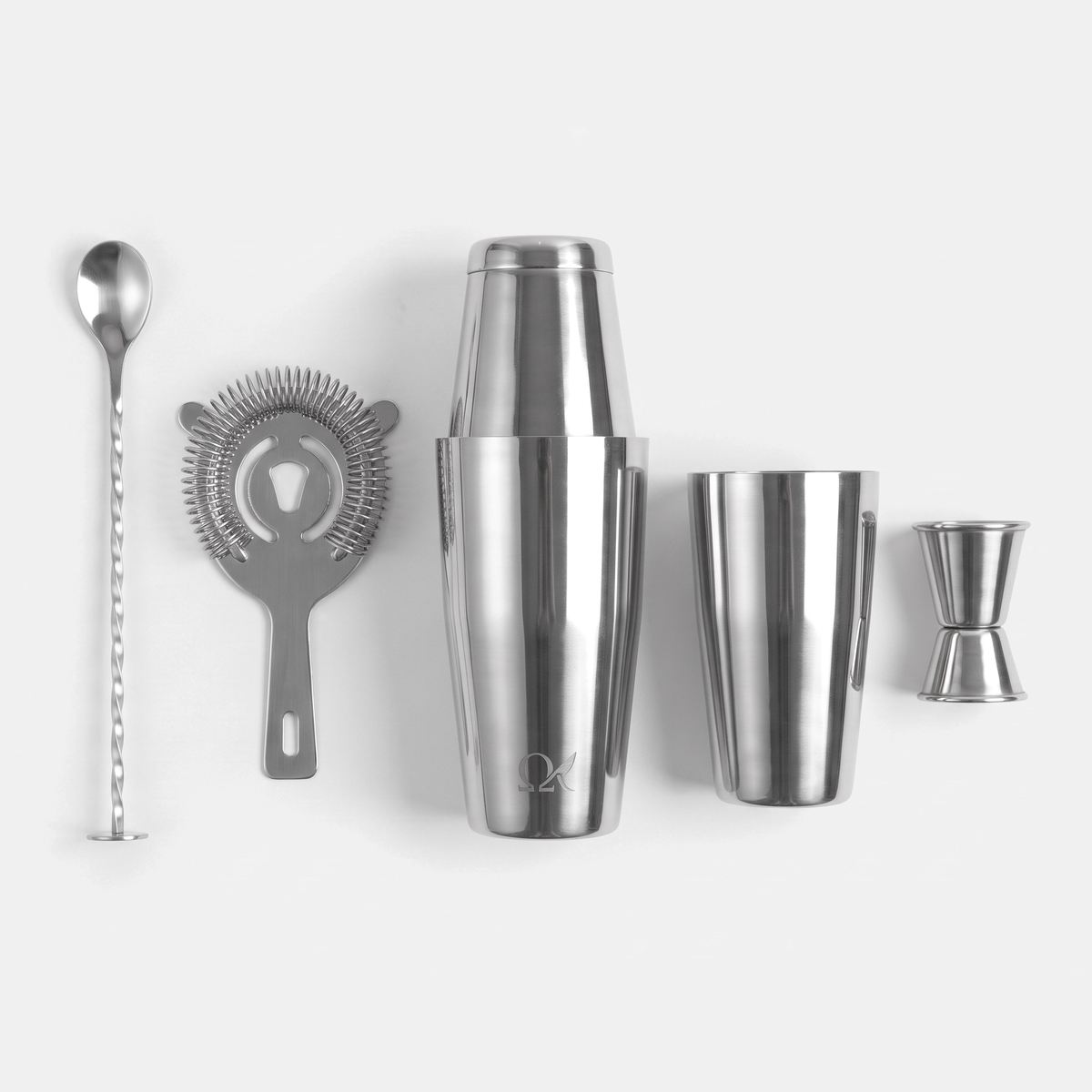 OMEGA 5-piece cocktail set laid out: two shaker tins, strainer, jigger and bar spoon