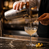 Pouring a cocktail from the OMEGA shaker through the strainer